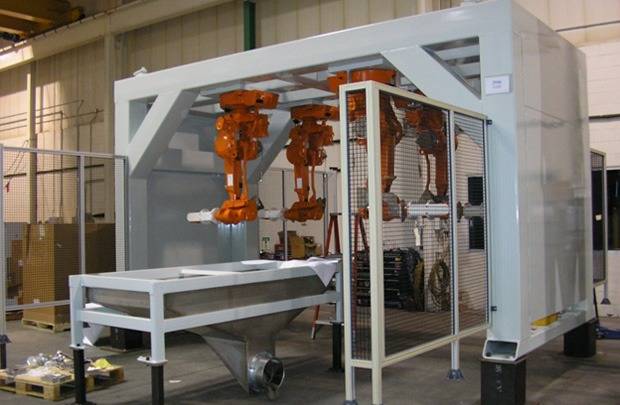 Large guarded fabricated enclosure with orange mechanical assemblies inside