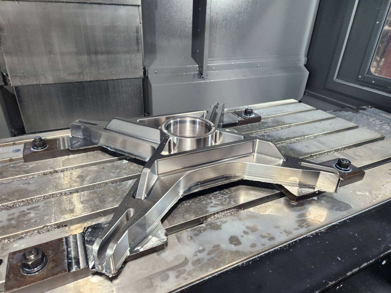 Precision-machined steel bracket fixtured on a machine table